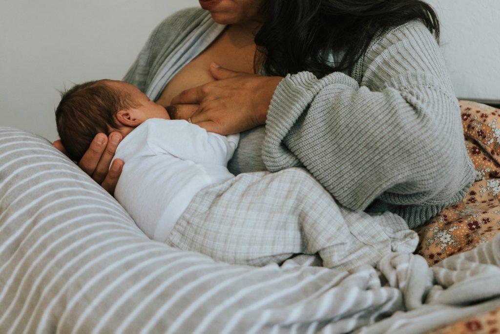 Woman sat in bed breastfeeding